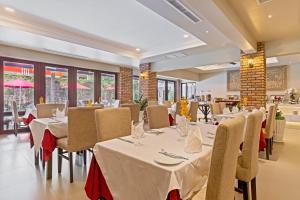 a restaurant with white tables and chairs and windows at Anik Boutique Hotel & Spa on Norodom Blvd in Phnom Penh