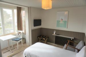 Een bed of bedden in een kamer bij Hotel Bon Accueil