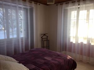 um quarto com cortinas brancas, uma cama e uma janela em Gîte des Infruits em Les Estables