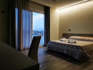 ヴィボ・バレンティア・マリーナにあるSARACENO HOTELのベッド2台と大きな窓が備わるホテルルームです。