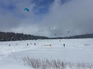 um grupo de pessoas soltando pipas na neve em Gîte des Infruits em Les Estables