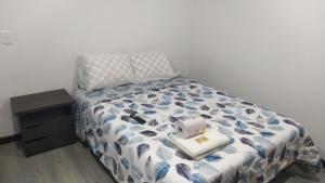 une chambre avec un lit avec une couette bleue et blanche dans l'établissement 6 Apartaestudio independiente, Cedritos, à Bogotá