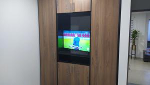 - une télévision dans un meuble en bois dans l'établissement 6 Apartaestudio independiente, Cedritos, à Bogotá