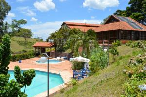 een huis met een zwembad en een gebouw bij Hotel Lago das Pedras in Apucarana