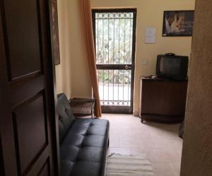 a living room with a couch and a television and a door at Agriturismo Masseria Portiere Stella in Gerbini