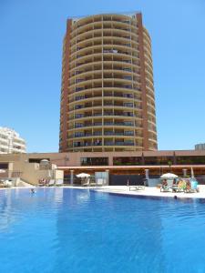 a large hotel with a swimming pool in front of a building at PRAIA DA ROCHA Appartement tout confort in Portimão