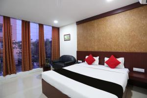 um quarto com uma cama grande e almofadas vermelhas em Hotel Best Inn em Bhubaneshwar