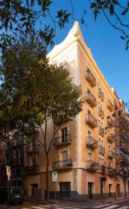 a large yellow building with balconies on a street at Casa Codina in Barcelona