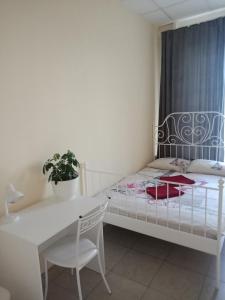 a small bedroom with a bed and a table and a desk at Hostel Milan in Moscow