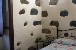 a bedroom with a wall covered in rock formations at "Rural House Servanda" - RELAX, NATURE, WIDE VIEWS OF THE SEA AND A STARRY SKY in Puntagorda