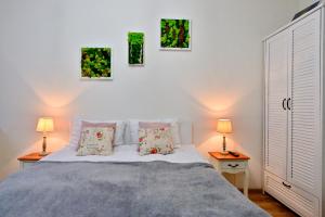 a bedroom with a bed and three paintings on the wall at Transilvania Apartment in Sibiu