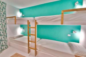 2 stapelbedden in een kamer met een groene muur bij LA VEDETTA dell’Eden by KlabHouse in Domus de Maria