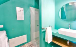 een blauwe badkamer met een wastafel en een spiegel bij LA VEDETTA dell’Eden by KlabHouse in Domus de Maria +16 foto's