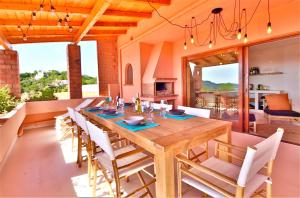 een eetkamer met een houten tafel en stoelen bij LA VEDETTA dell’Eden by KlabHouse in Domus de Maria