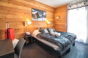 een slaapkamer met een bed en een rode koffer bij ALPINA LODGE VANOISE ex hotel du soleil in Aussois