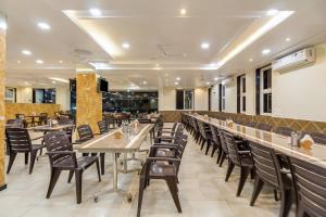 un restaurante con mesas y sillas y un bar en Hotel Om Inn - Talegaon Dabhade en Talegaon Dābhāde