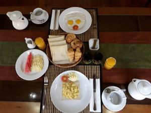 a table with plates of breakfast food on it at Apel Villa Sanur in Sanur