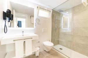ein Badezimmer mit Toilette, Waschbecken und Dusche in der Unterkunft Aparthotel Ciudad Laurel in Cala Millor