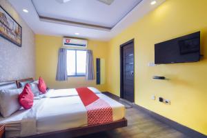 um quarto com uma cama e uma televisão de ecrã plano em Kiaan Inn em Calcutá