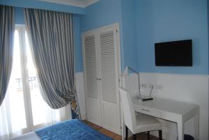 a room with a bed, table and window at Helios Hotel in Crotone