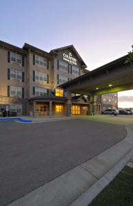 un grand bâtiment avec un parking en face de celui-ci dans l'établissement Country Inn & Suites by Radisson, Grand Forks, ND, à Grand Forks