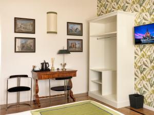フィレンツェにあるFlor in Florenceのデスク、椅子、テーブルが備わる客室です。