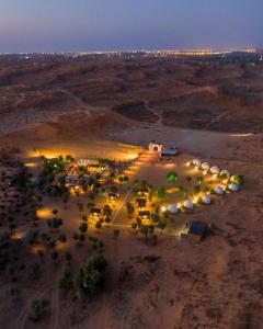 The Dunes Camping & Safari RAK في رأس الخيمة: اطلالة جوية على موقف للسيارة في الصحراء ليلا