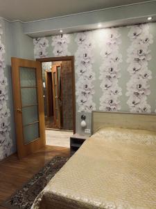 マグニトゴルスクにあるApartment on Chapaeva 5/1のベッドルーム1室(ベッド1台付)、花の壁