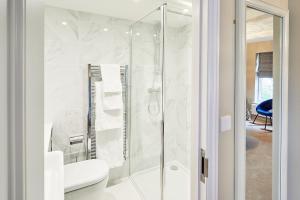 a white bathroom with a shower and a toilet at The New Inn in Hereford