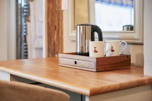 eine Kaffeemaschine und zwei Tassen auf dem Tisch in der Unterkunft The New Inn in Hereford