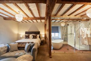 a bedroom with a bed and a tub in a room at The New Inn in Hereford