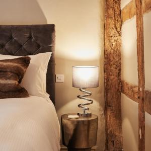 um quarto com uma cama e um candeeiro sobre uma mesa em The New Inn em Hereford