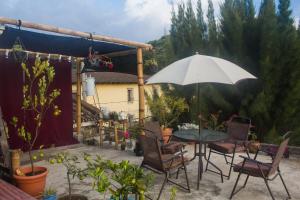 patio ze stołem, krzesłami i parasolem w obiekcie Casa Familiar w mieście Antigua Guatemala