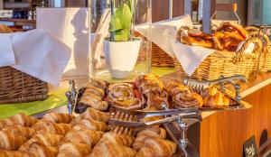 a table with a bunch of pastries and baskets of bread at Crowne Plaza Frankfurt Congress Hotel by IHG in Frankfurt/Main