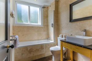 Un baño con lavabo, inodoro y ventana. en Classroom Flat Suite in a converted school in Fowey town centre, en Fowey 16 fotos más
