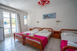 sypialnia z 2 łóżkami i oknem w obiekcie Villa Limnes w mieście Perissa