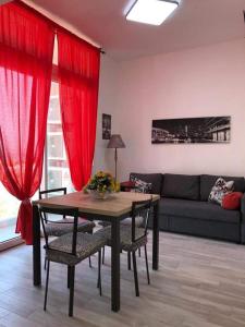 soggiorno con tavolo e tende rosse di L 'APPRODO FELICE a Palermo