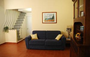 a living room with a blue couch and stairs at Santacroce 52 in Florence