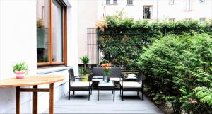 a patio with a table and chairs and a hedge at 90sqm 2BR Design Gem - outdoor terrace in Berlin