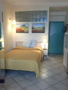 um quarto com uma cama e duas pinturas na parede em DEPANDANCE CASA ANDREA em Taormina