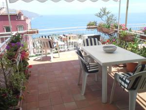 uma mesa e cadeiras num pátio com vista para o oceano em DEPANDANCE CASA ANDREA em Taormina mais 2 fotografias