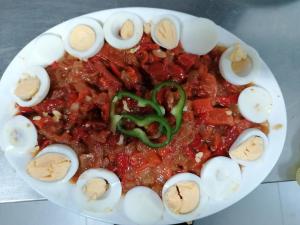 un plato de comida con salsa y huevos. en Balcón del Velillos-"Rincón de Marcelo", en Tózar