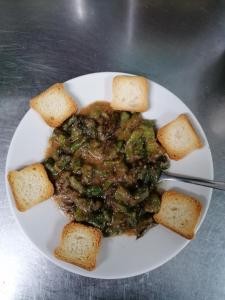 a white plate of food with meat and bread at Balcón del Velillos-"Rincón de Marcelo" in Tózar