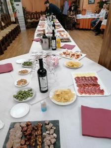 Balcón del Velillos-"Rincón de Marcelo" في Tózar: طاولة طويلة مليئة بالطعام وزجاجات النبيذ