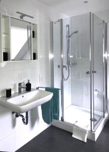 a white bathroom with a shower and a sink at Altstadtperle Nideggen in Nideggen