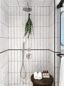 een douche in een betegelde badkamer met een houten tafel bij White Elephant Palm Beach in Palm Beach