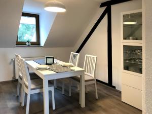 a dining room with a white table and chairs at Altstadtperle Nideggen in Nideggen