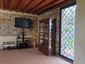 - un salon avec une télévision sur un mur en pierre dans l'établissement Casa Buriano, à Quarrata