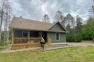 a small green house with a large porch at Beaver Brook Chalet in Wilmington