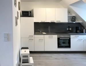 a kitchen with white cabinets and a stove top oven at Altstadtperle Nideggen in Nideggen